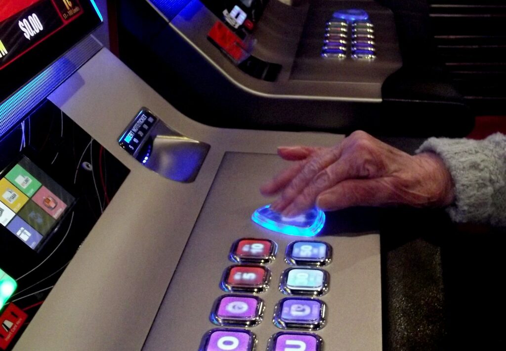 Elderly lady playing a casino slot machine